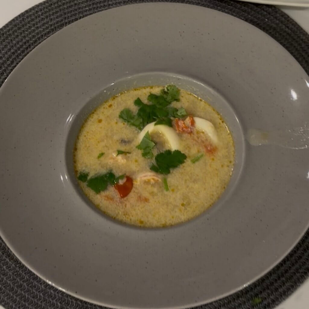 Tom Yum coconut seafood soup with shrimp, squid, mushrooms and rice